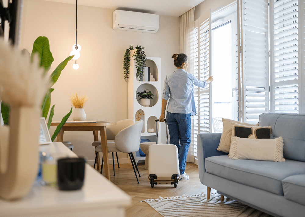 Traveler with suitcase in bright apartment