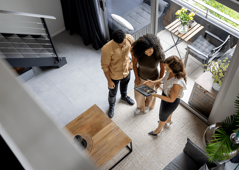 Real estate agent showing tablet to couple